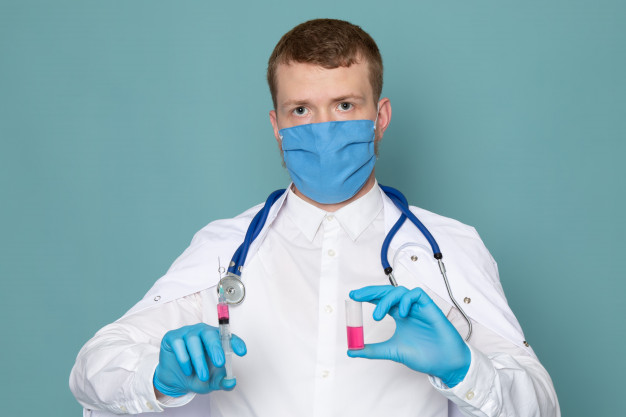 um homem de vista frontal em luvas brancas de terno medico azul e mascara azul no espaco azul
