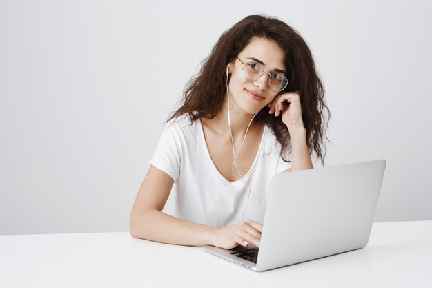 mulher muito sorridente trabalhando em um projeto via laptop e sentar na mesa