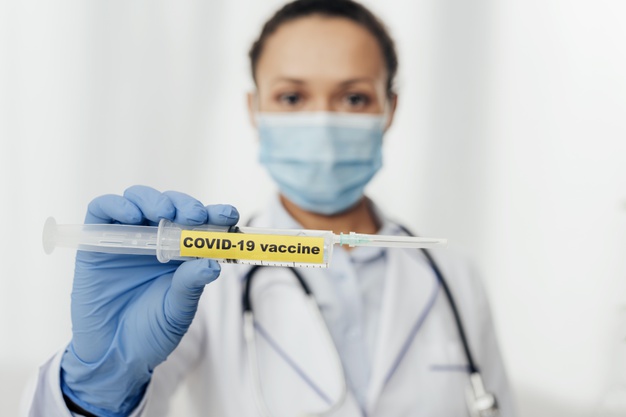 close up doctor holding covid vaccine