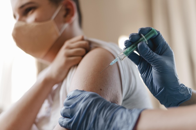 medico dando vacina a crianca usando luvas