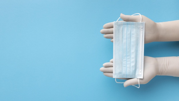 vista superior das maos com luvas segurando mascara medica com espaco de copia