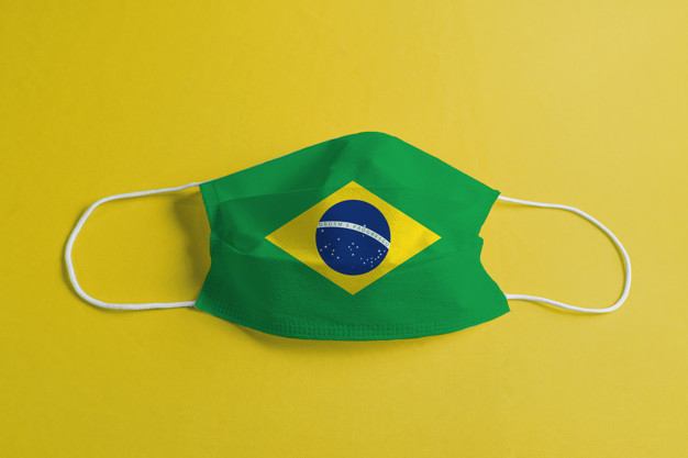 Surgical mask on yellow background with Brazilian flag