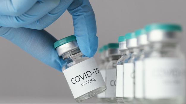 medico segurando um frasco de vacina covid