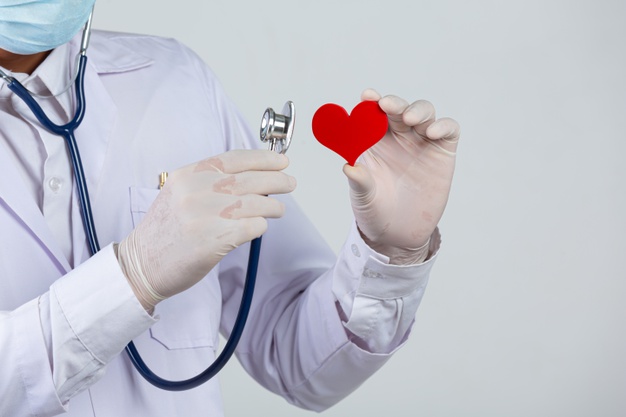 dia mundial da diabetes medico segurando um estetoscopio e um coracao vermelho em forma de madeira