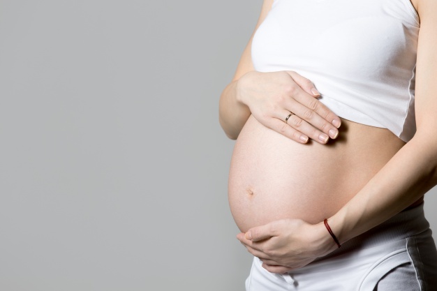 mulher gravida que toca em sua barriga