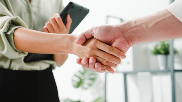 grupo multirracial de jovens criativos em roupas casuais inteligentes discutindo negocios apertando as maos juntos