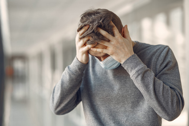 homem em uma mascara de pe no corredor do hospital
