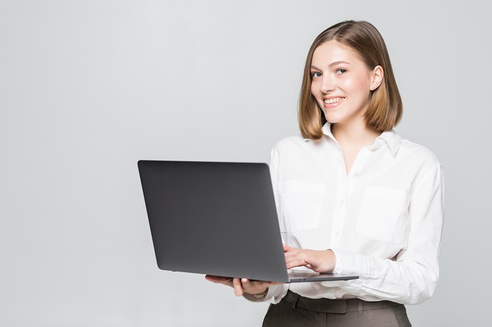 Attractive businesswoman with laptop against white background