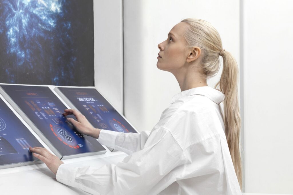 side view woman working on digital monitors
