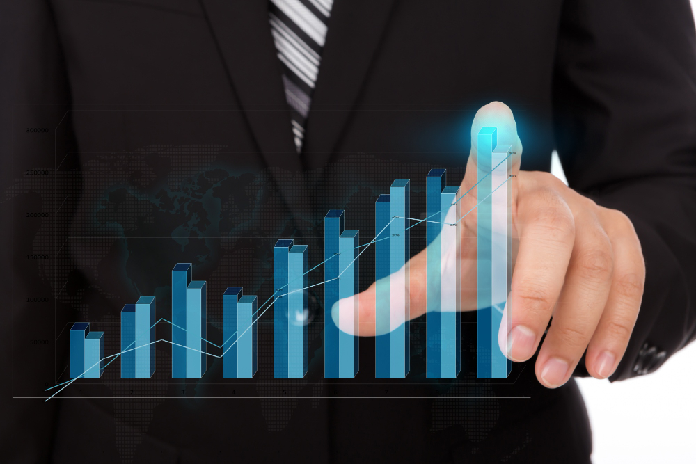 businessman touching the tip of a bar chart