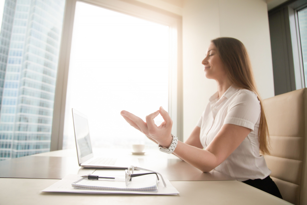 calm peaceful businesswoman practicing yoga at work meditating in office
