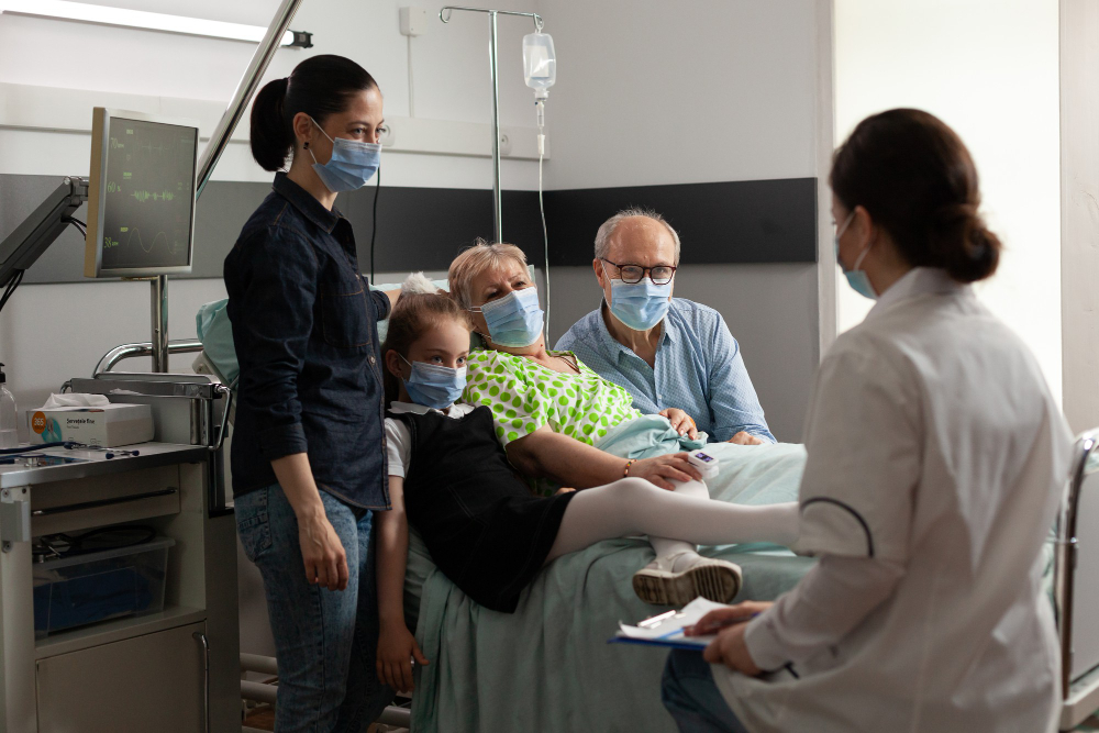 family visiting elderly senior woman patient while wearing protective face mask