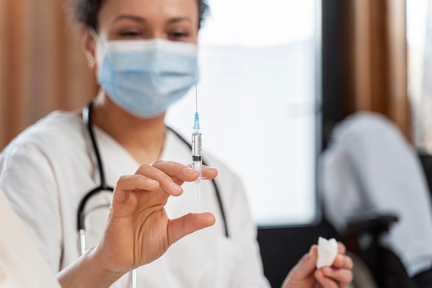 medico preparando a vacina para uma mulher idosa