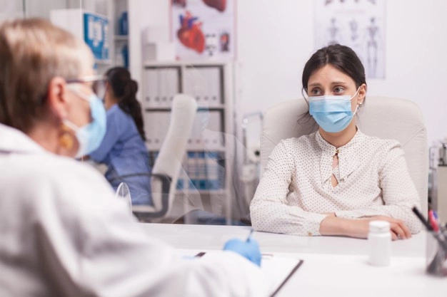 paciente jovem estressado com mascara facial contra covid durante consulta com medico senior no consultorio do hospital mulher apavorada