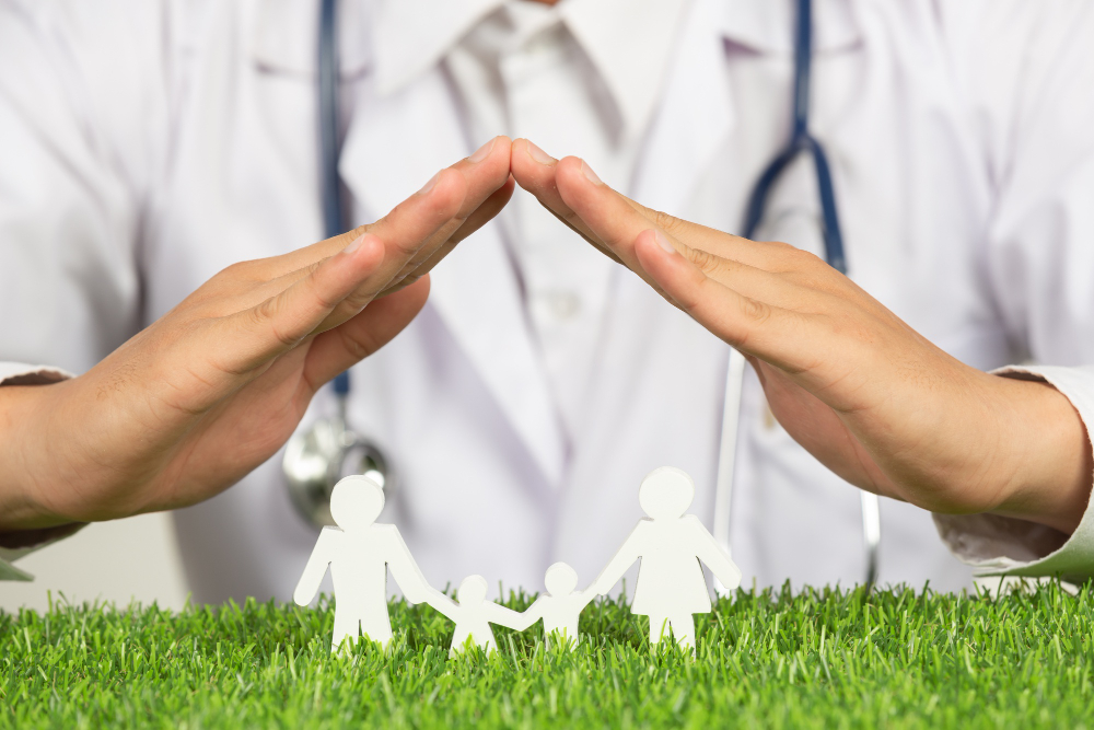 close up picture of doctor s hands posting symbol of home above family member model