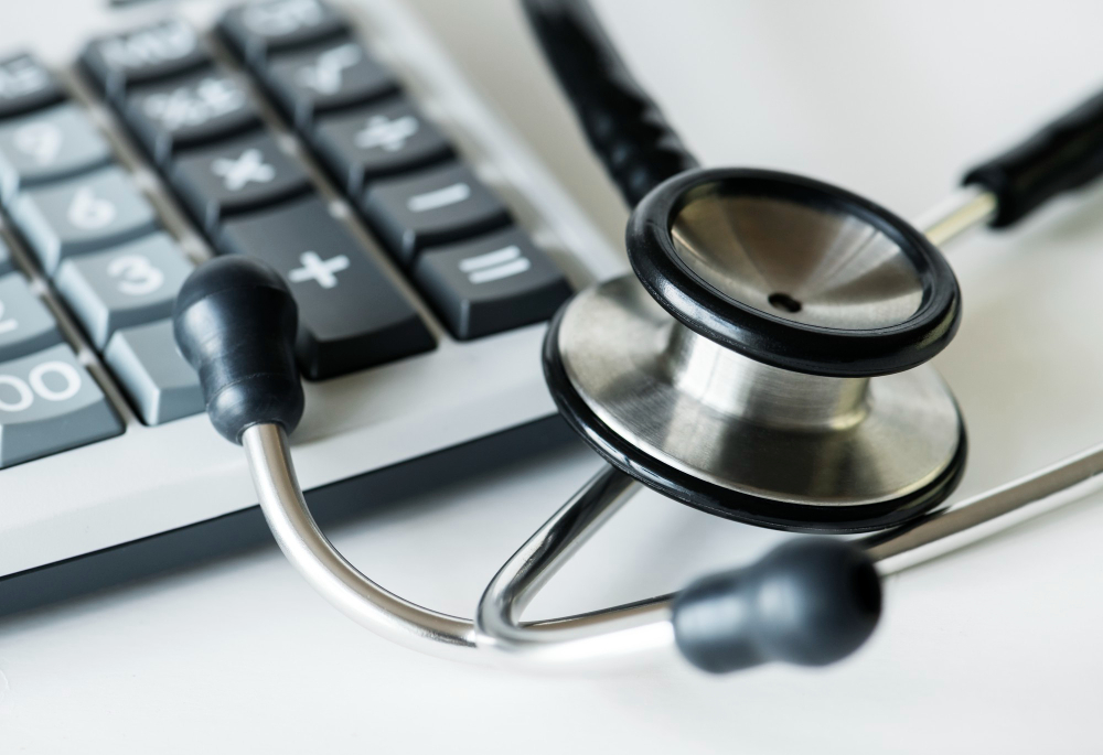 closeup of a calculator and a stethoscope healthcare and expenses concept
