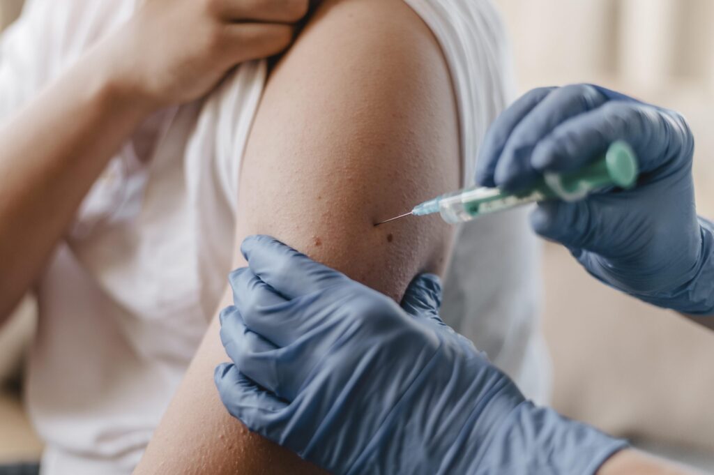 doctor giving child a vaccine while wearing gloves