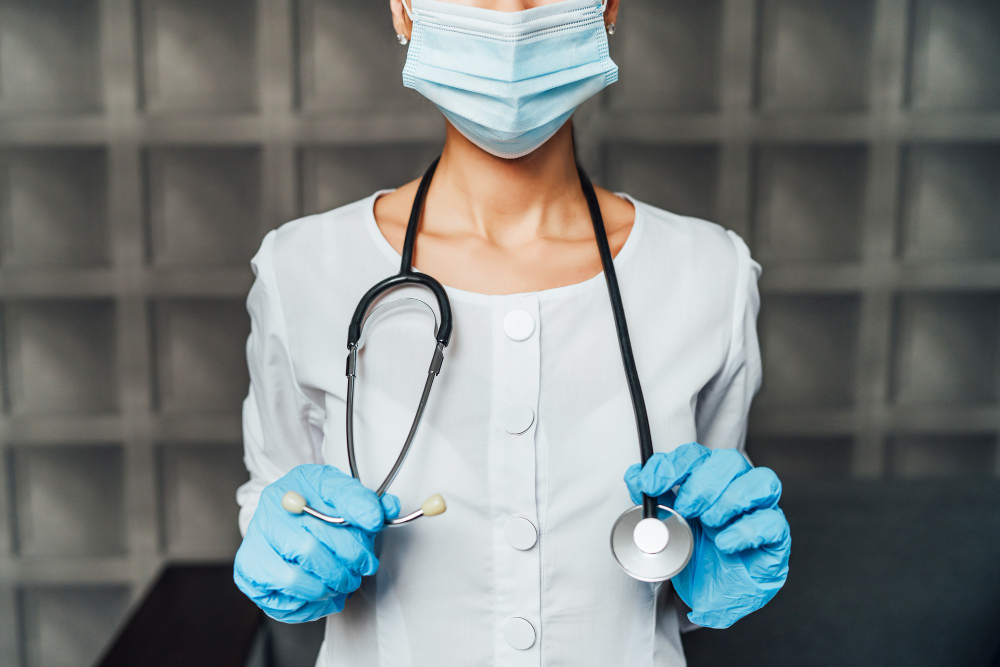 close up of nurse in protective mask with stethoscope and protective gloves