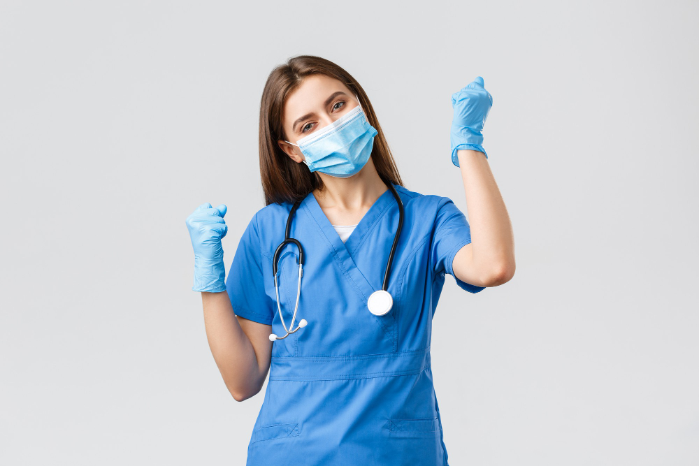 covid preventing virus health healthcare workers and quarantine concept cheerful optimistic female nurse winning celebrating victory fist pump upbeat smiling in medical mask and gloves