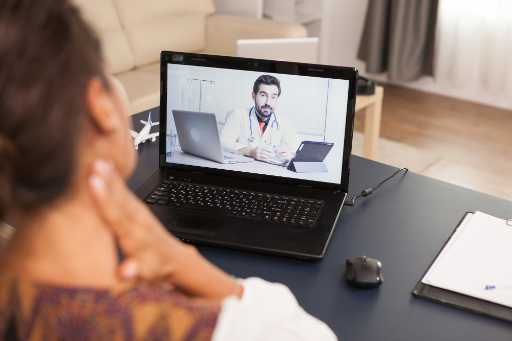 female patient in a video call with doctor talking about her neck injuri