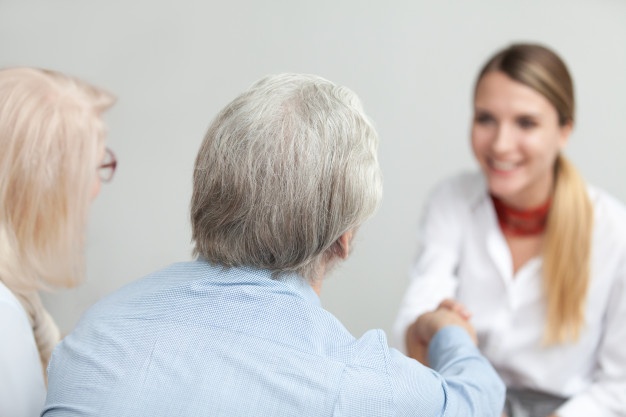 vista traseira em par senior handshaking conselheiro ou medico trabalhador