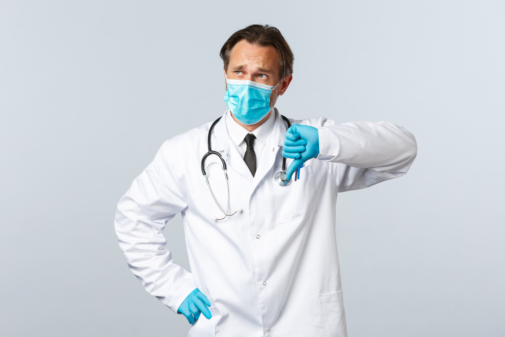 covid preventing virus healthcare workers and vaccination concept skeptical and disappointed doctor in medical mask gloves show thumb down displeased look top left sad