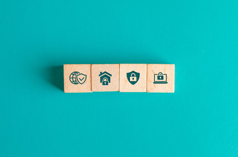 security concept with icons on wooden blocks on turquoise table flat lay