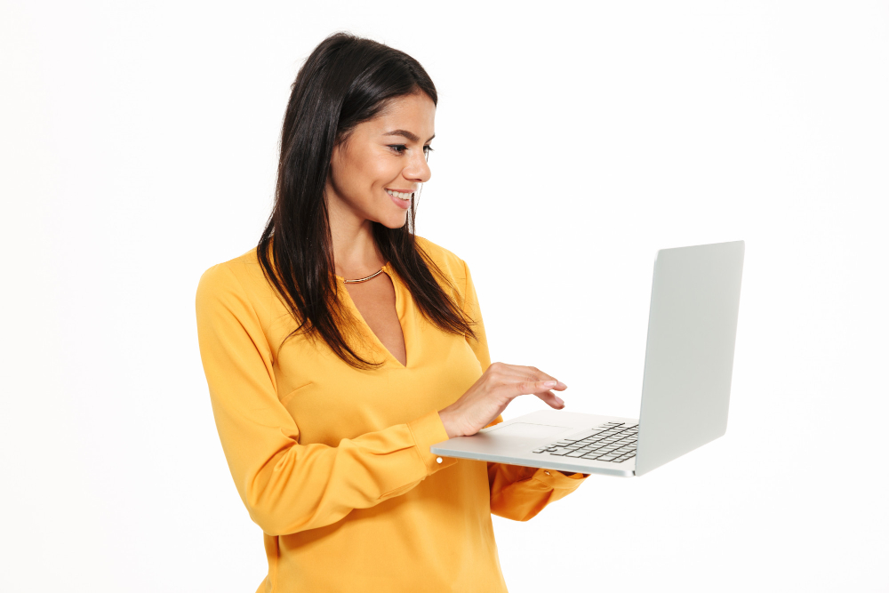 portrait of a smiling young woman working on laptop