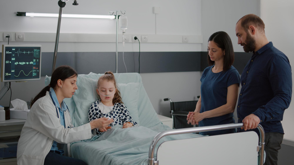 practitioner woman doctor putting medical oximeter on little child patient finger monitoring heartbeat pulse during recovery consultation black nurse checking iv drip bag working in hospital ward