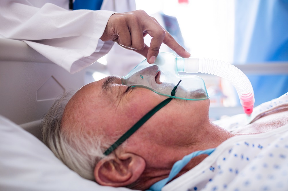Hand of female doctor putting oxygen mask on patient face in the hospital