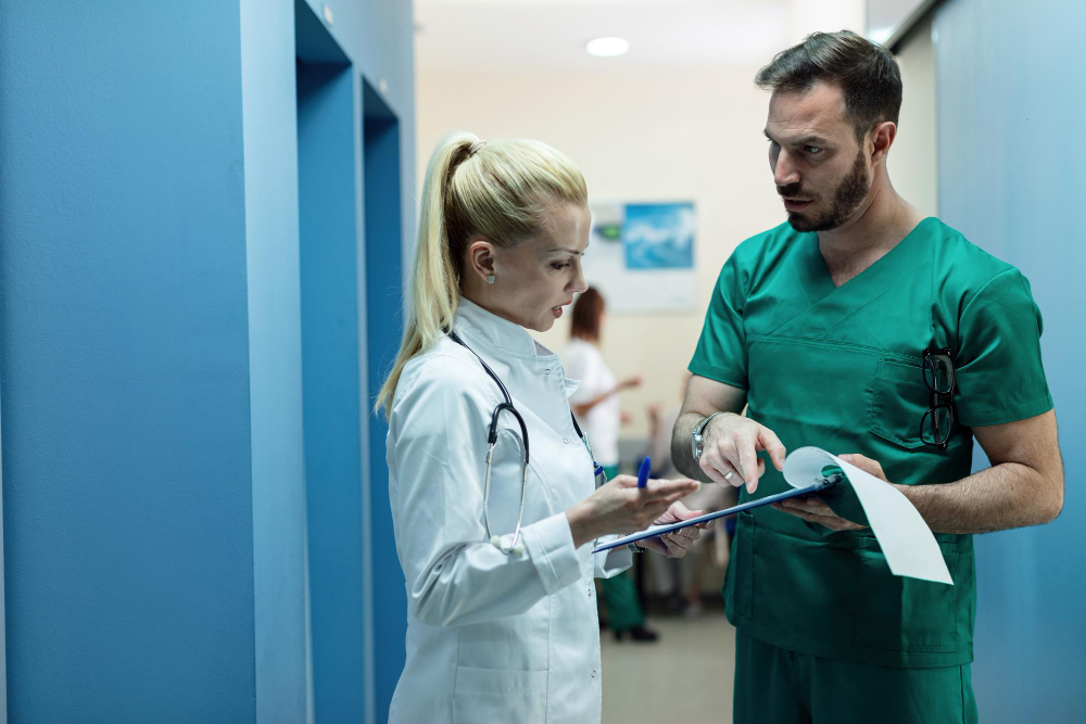 surgeon and female doctor going through patient s medical record while standing hospital lobby