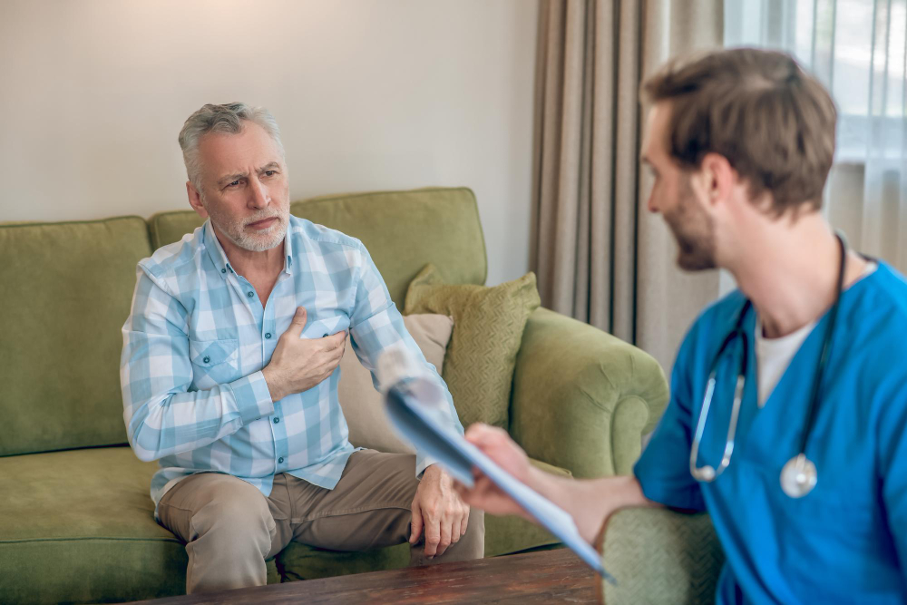 upset gray haired man in a plaid shirt complaining of his chest pain to a cardiologist