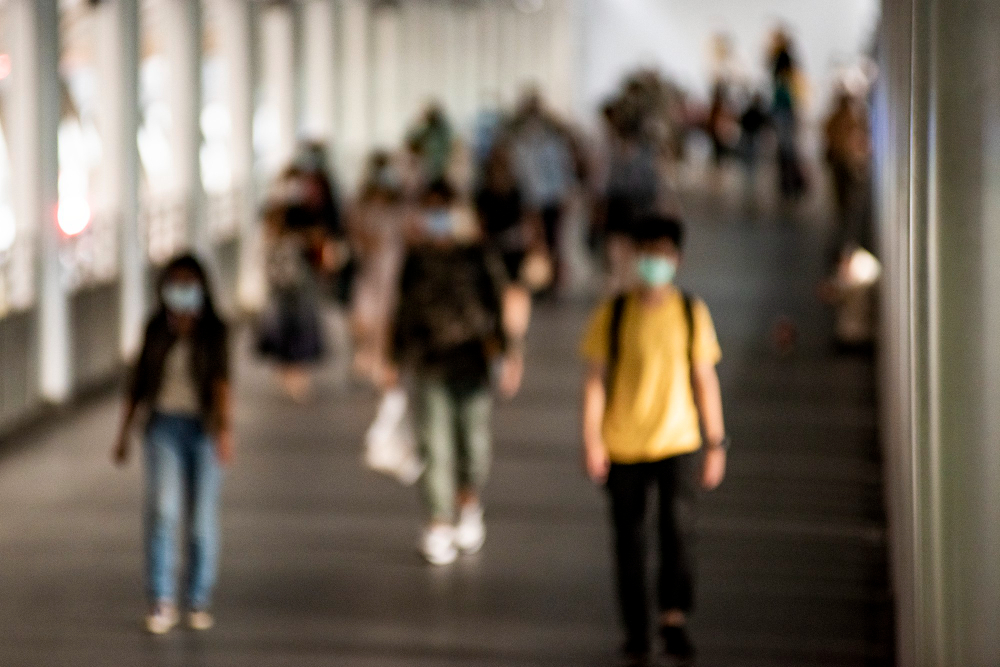 crowd of people wearing mask walking in the new normal