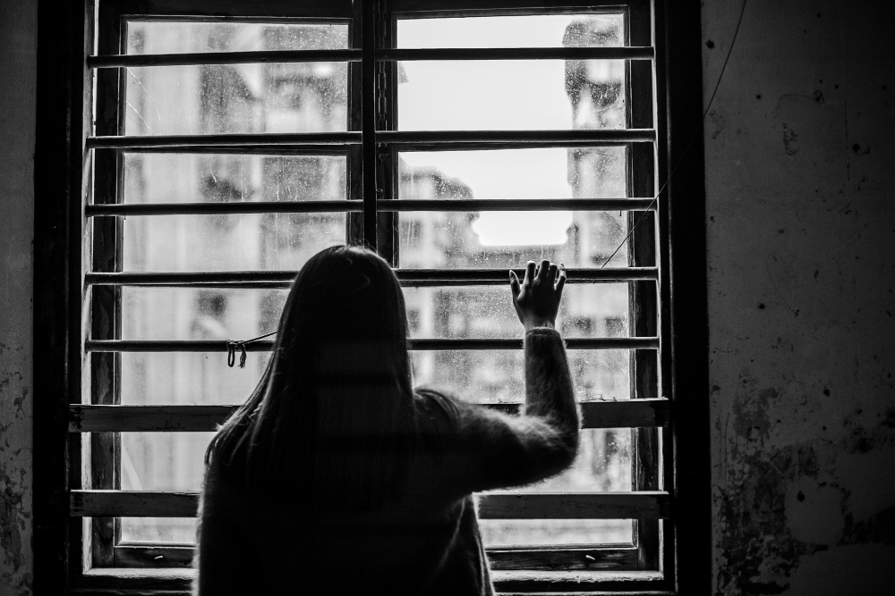 rear view of sad woman next to the window