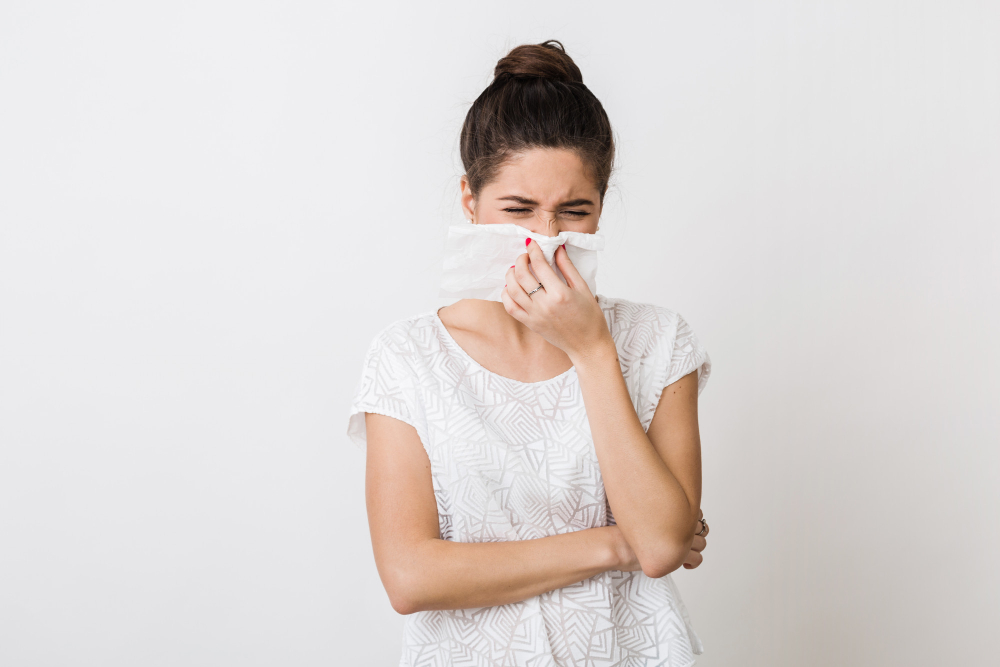 close up portrait of pretty woman blowing her nose with napkin catch a cold feeling sick isolated frowning