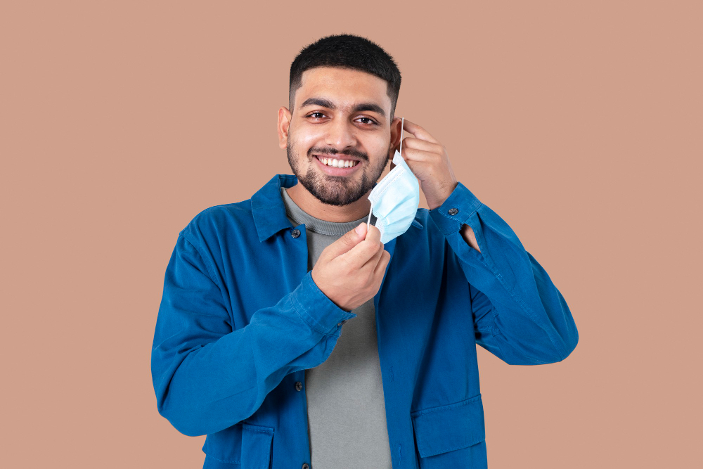 man taking mask off during the new normal