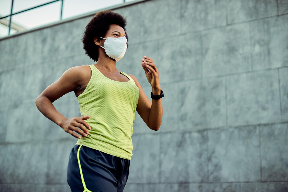below view of black female runner with protective face mask