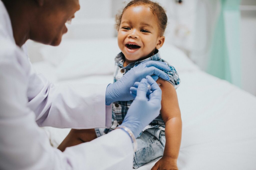 toddler getting a vaccination by a pediatrician