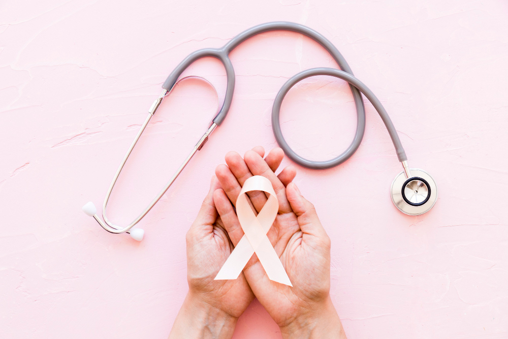 white awareness ribbon in two hands with stethoscope on pink background