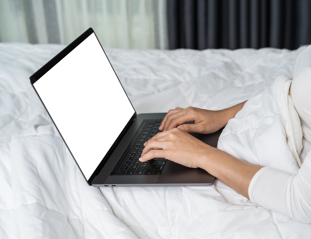 closed up woman using laptop computer bed