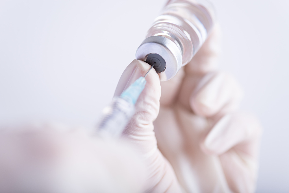 female doctor hands holding syringe and vaccine