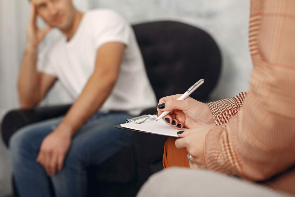 man sitting psychologist s office talking about problems scaled