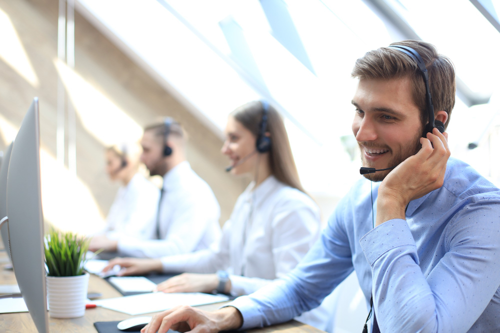 portrait call center worker accompanied by his team smiling customer support operator work