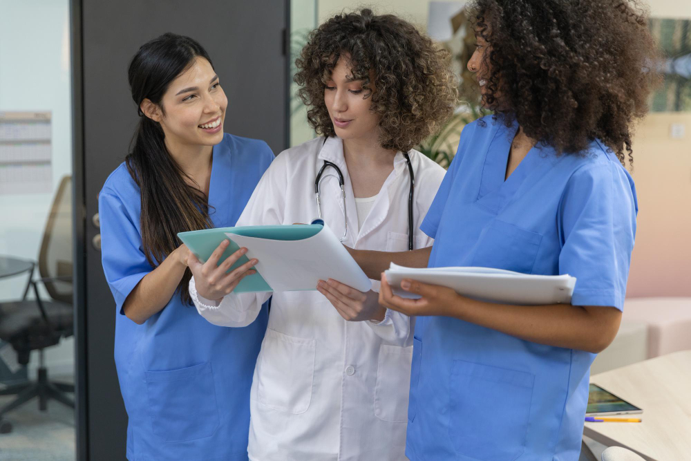 equipe de trabalho medico feminino jovem vestindo uniforme azul sorrindo e olhando uns aos outros