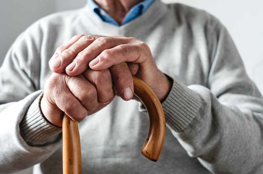 hands elderly man resting walking cane