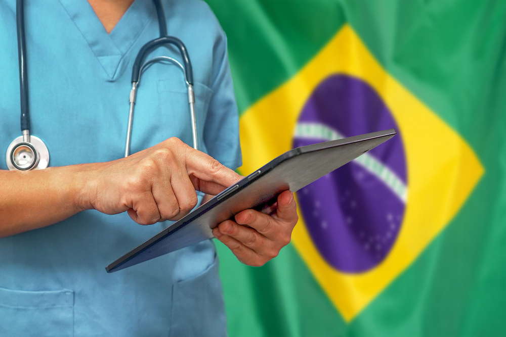 cirurgiao ou medico usando tablet digital no fundo da bandeira do brasil