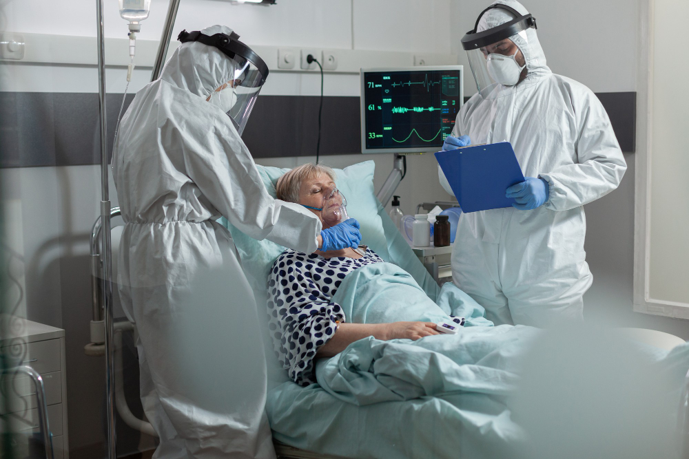medical staff ppe suit helping patient breath with oxygen mask