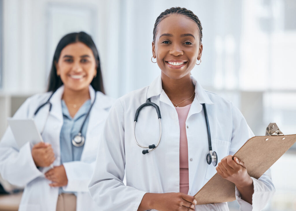 Healthcare, women and doctors with patient chart on clipboard in hospital or clinic Happy black woman doctor, medical partnership and insurance documents, diversity and leadership in health care