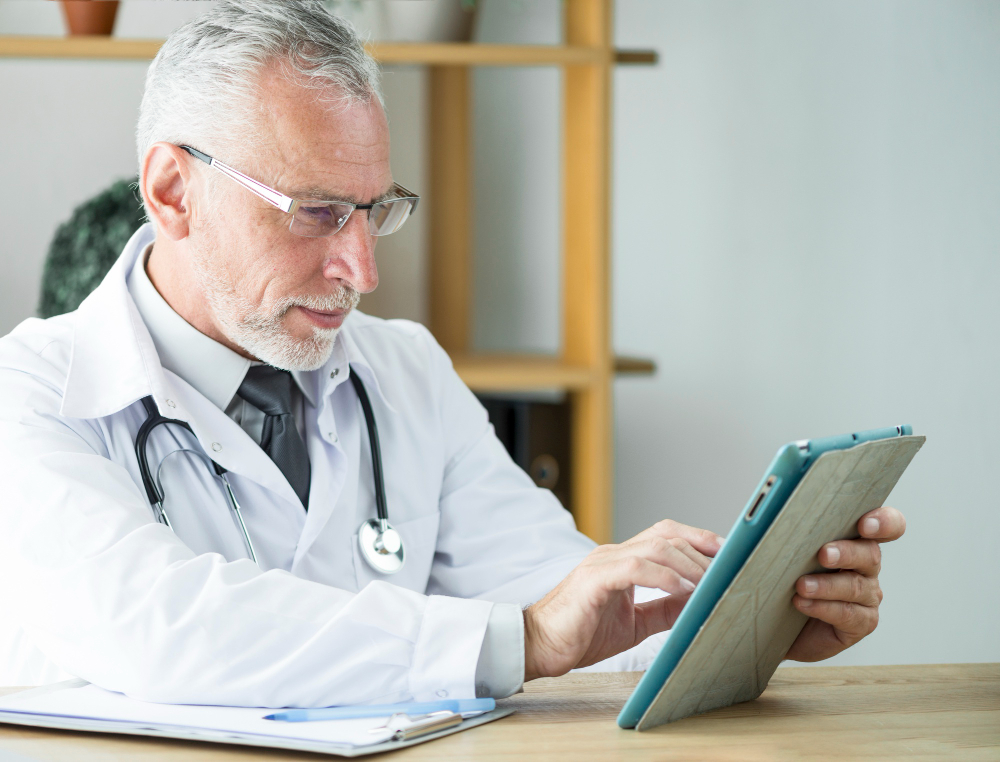 elderly doctor using tablet office