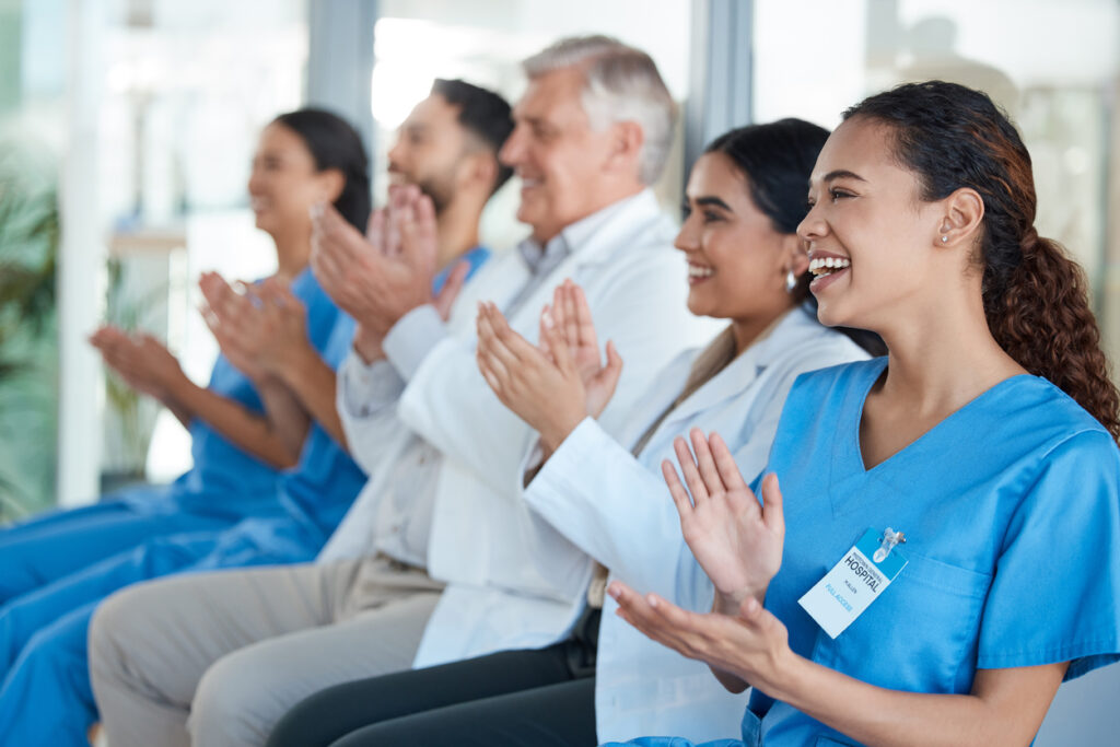 Shot of a team of medical staff applauding during a conference